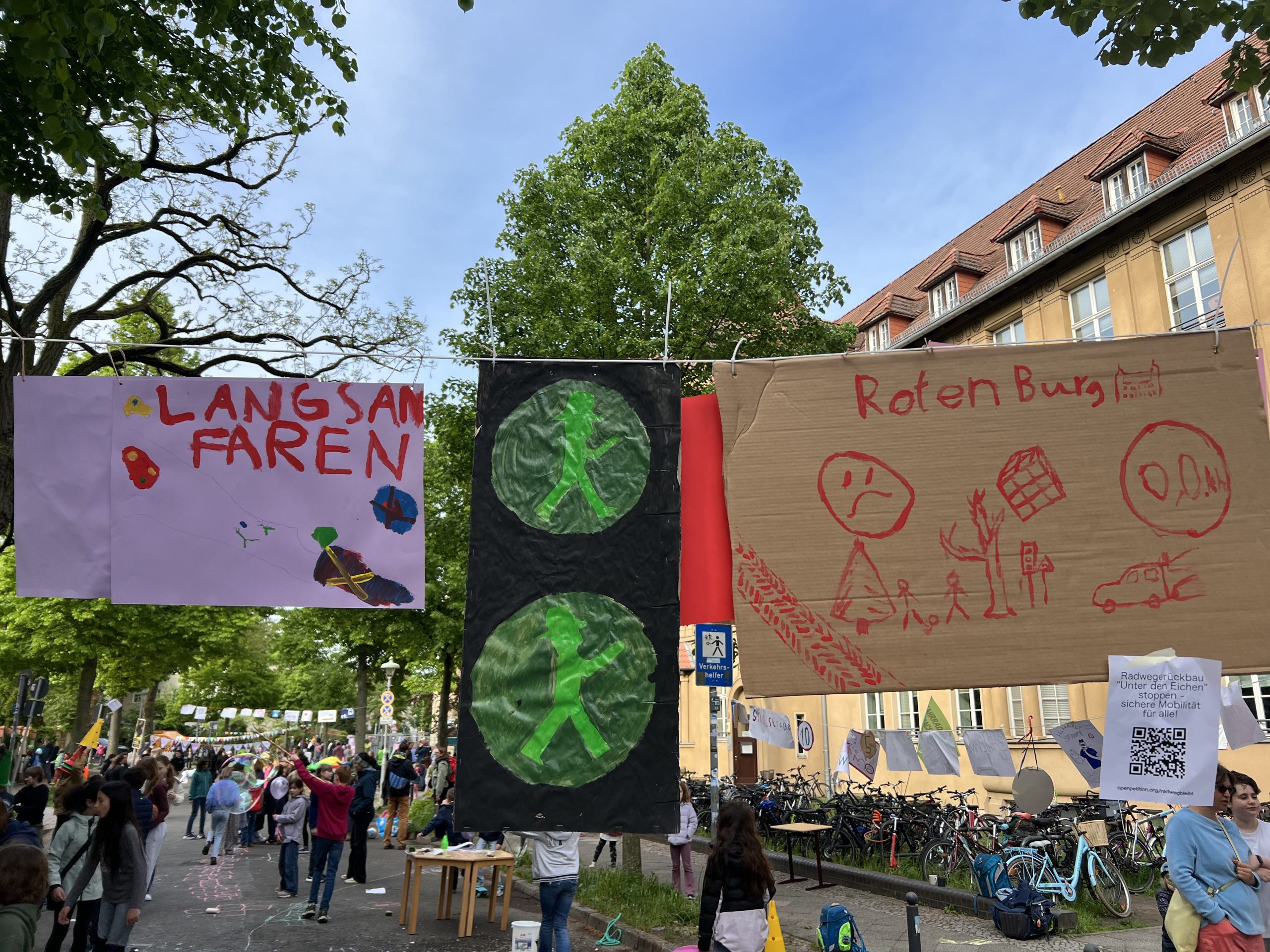 Für die Schulstraßenaktion hängen vor der Schule von den Kindern gemalte Plakate quer über der Rothenburg-Straße.