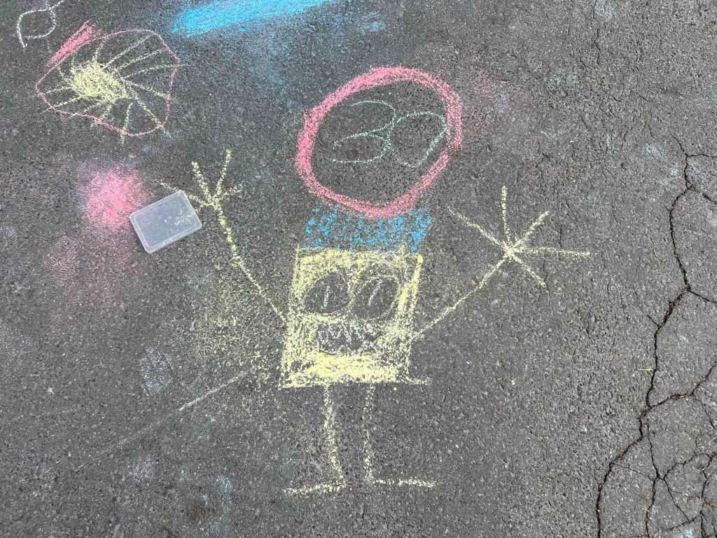 Mit Straßenkreide haben Kinder für die Schulstraßenaktion ein 30-Schild auf die Straße vor der Schule gemalt.