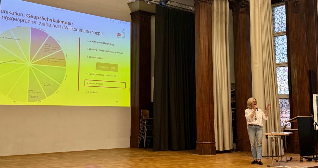 Die Schulleiterin Frau Krins erläutert in der Aula unseren Gesprächskalender.